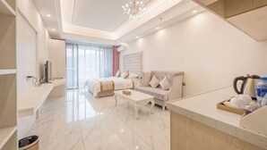 Une chambre d’hôtel moderne équipée d’un lit, d’un canapé, d’une table basse et d’un coin cuisine.