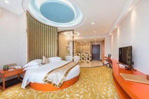 A modern hotel room with a bed, a desk, a TV, and a bathroom visible through a glass door. - Fuyue Holiday Hotel(fuhua street store) (Zhongshan)