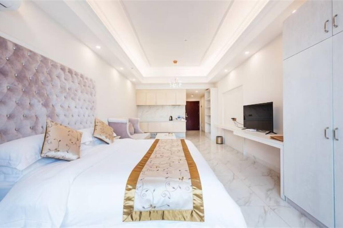 Een moderne hotelkamer met een groot bed, een televisie en een minibar.