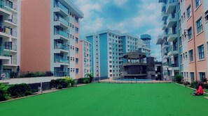 Stylish apartment complex with modern architecture and beautifully maintained green spaces.