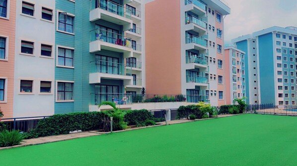 Stunning residential building with balconies and beautifully manicured grounds.