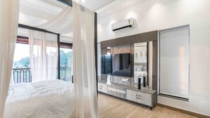 Ein modernes Schlafzimmer mit einem Bett, einem Frisiertisch mit Spiegel und einer Klimaanlage.