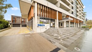 A modern building with a sign reading 'ISKIA' and a staircase leading to the entrance. - Inner-City 2-Bed with Large Balcony, Garden & Gym (Campbell)