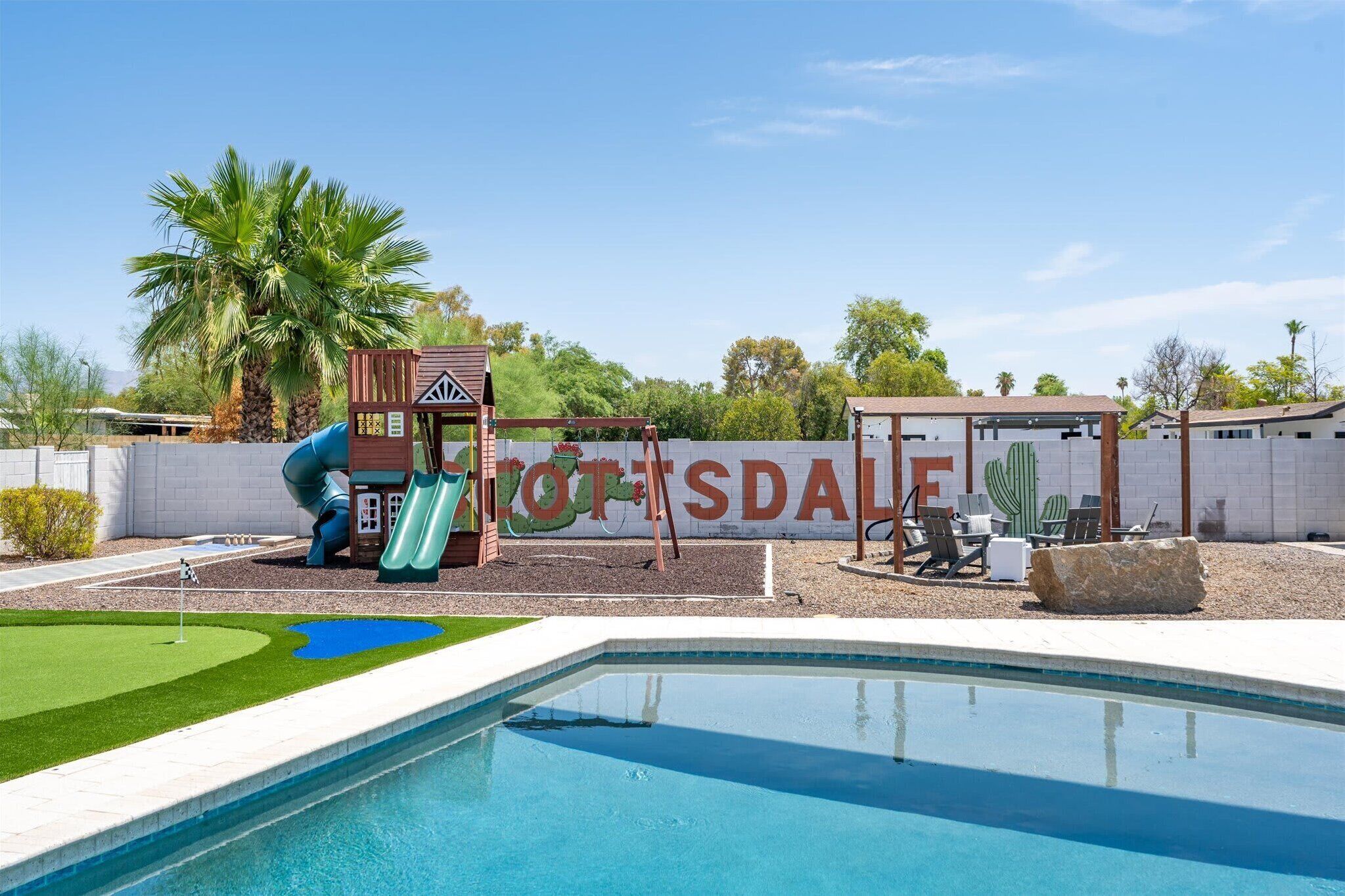 Une piscine avec un espace de jeux pour enfants, un toboggan et un panneau indiquant « ROTTSDALE ».