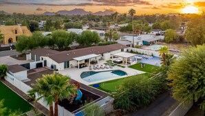 A residential area with a swimming pool, outdoor seating, and a view of mountains.