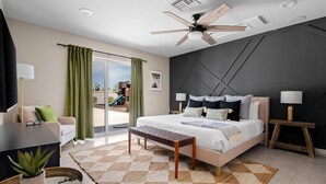 A modern hotel room with a large bed, a ceiling fan, a view of the outside, and a small table with a plant.