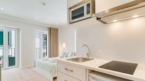 A modern kitchen with a built-in microwave, a sink, and a countertop with a built-in induction cooktop. - Q Studios 2 by Atlantic Holiday (Funchal)