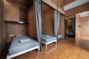 A modern room with two beds, wooden flooring, and a high ceiling. - Ed Hostel Rachamakka (Chiang Mai)