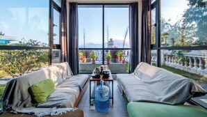 A modern living room with a sofa set, a coffee table, and a large water dispenser. - West Lafayette seaview Inn (Shenzhen)