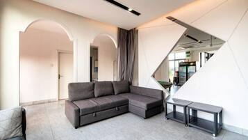 Una sala moderna con un sofá modular, un banco y una escalera.