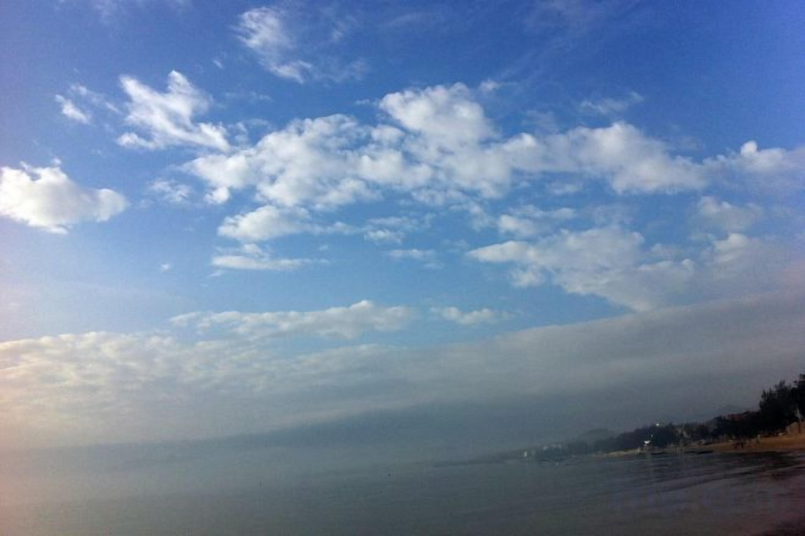 A coastal landscape with a clear sky and calm sea.