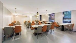 A modern dining area with multiple tables and chairs, featuring pendant lighting and large windows. - Benison VII Boutique Hotel (Urumqi)