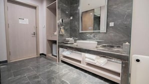 A modern bathroom with a marble vanity, a large mirror, and a door with a sign.