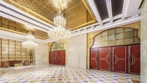 A spacious lobby with a patterned floor, large chandeliers, and a seating area with sofas. - Benison VII Boutique Hotel (Urumqi)
