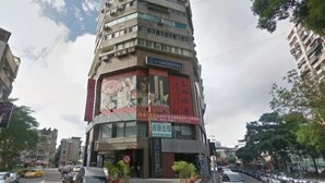 Um hotel com vários andares e uma placa chamativa com o nome "Hotel 10/11".