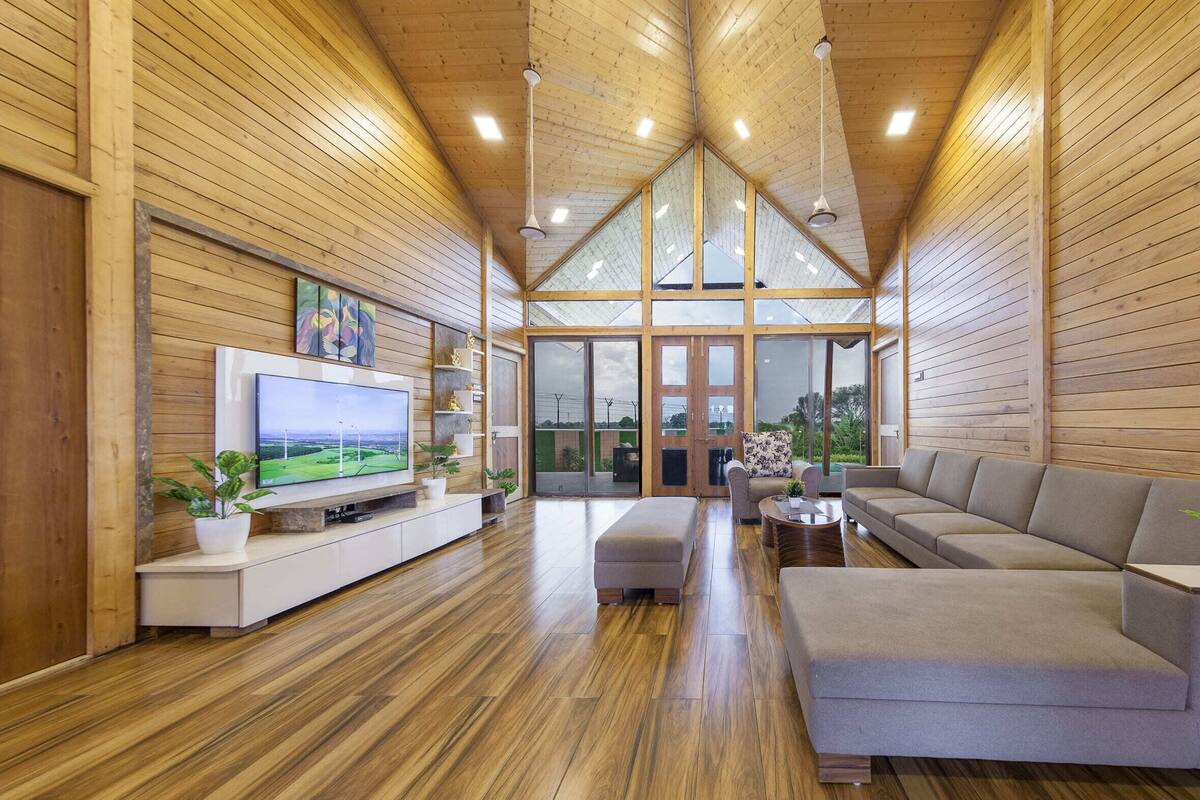 A modern interior with wooden paneling, a flat-screen TV, a sofa, and a coffee table.