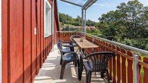 A balcony with a wooden table and plastic chairs, overlooking a green landscape. - Apartment 'Fewo Mit Balkon Am Wald 2-4 Pers' with Mountain View, Private Garden and Wi-Fi (Bad Sachsa)