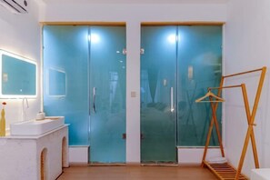 Una habitación con un tocador blanco, un espejo y un perchero de madera.