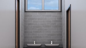 Un baño con dos lavamanos, una ventana y un armario de madera.