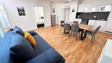 A modern apartment with a living room, dining area, and kitchen.