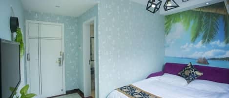 Une chambre avec un lit, une porte, un mur orné d’une fresque tropicale et des lampes suspendues.