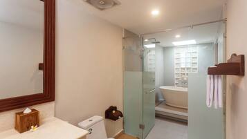 A modern bathroom with a glass-enclosed shower, a white sink, and a wooden vanity.