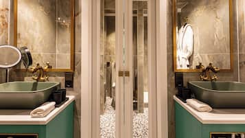 Une salle de bain avec deux lavabos, une douche en verre et un grand miroir.