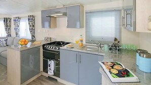 A compact kitchen with a gas stove, oven, and a small sink.