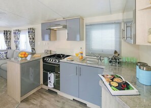 A compact kitchen with a gas stove, oven, and a small sink.