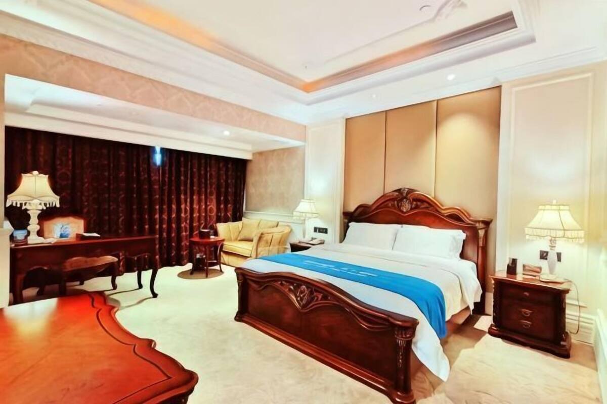 Una habitación de hotel con una cama grande, un escritorio, una silla y un sofá.