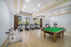 A room with exercise equipment, a pool table, and large windows. - New Century International Hotel (Wuyue Square Branch, Tianchang Municipal Government) (Tianchang)