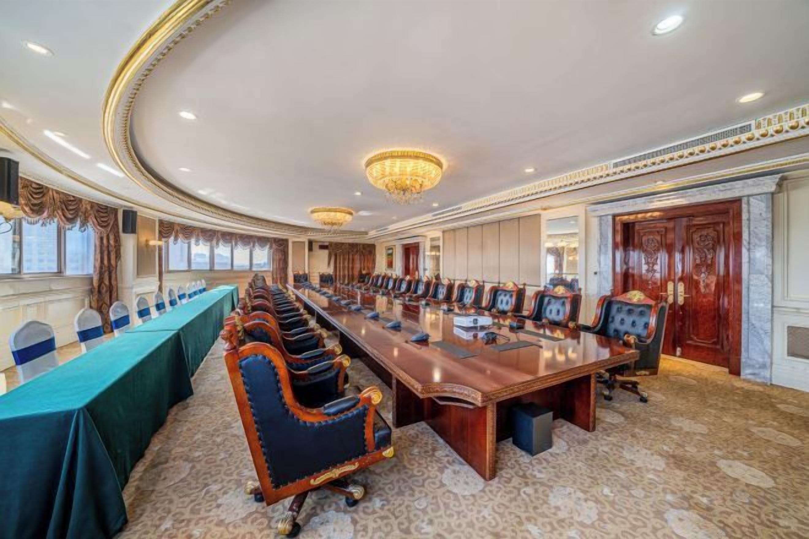 A conference room with a long table, chairs, and a chandelier.