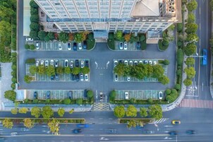 Vista aérea de un edificio moderno con varios estacionamientos y áreas verdes.