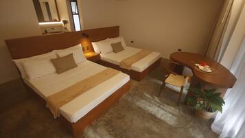 Habitación de hotel con dos camas individuales, una mesita, una silla y una planta en maceta.