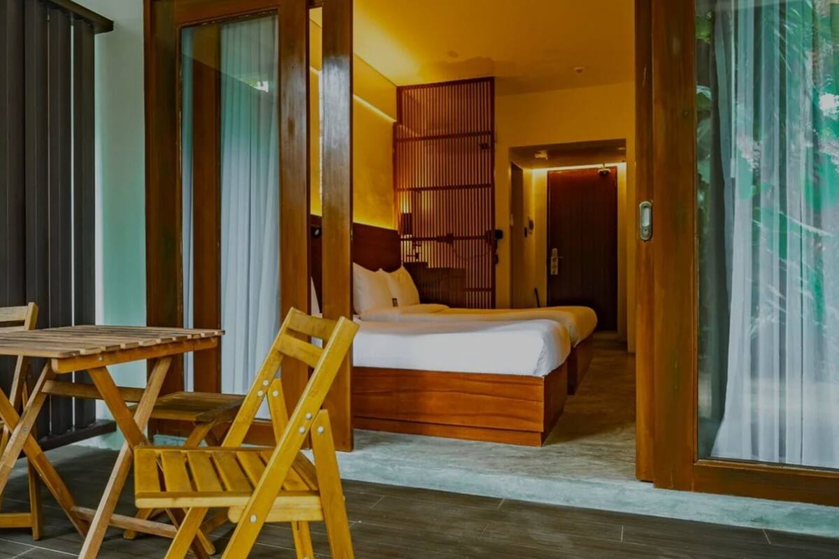 Une chambre d’hôtel avec un lit, une table en bois et des chaises.