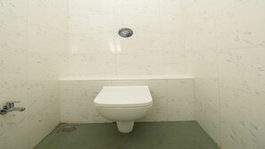 A small, narrow bathroom with a toilet, a sink, and a shower. - Rebel De Pondicherry (Puducherry)