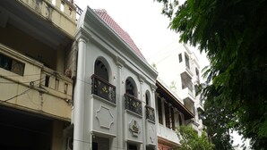 A two-story building with a white facade and a red-tiled roof. There is a sign for Maison Perumal Heritage Hotel on the front. - Rebel De Pondicherry (Puducherry)