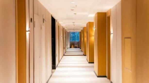 A hotel corridor with a long, straight layout, doors on both sides, and a central walkway. - Huangguan Holiday Hotel (Liyang)