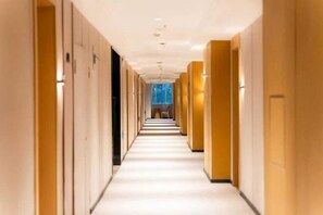 En hotellkorridor med ett långt, rakt utrymme, dörrar på båda sidor och en central gångväg.