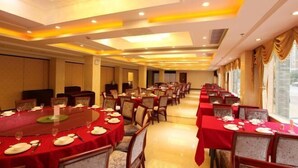 A banquet hall with round tables covered in red tablecloths, arranged in rows. - Huangguan Holiday Hotel (Liyang)