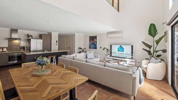 Un espacio habitable moderno con comedor, sofá y cocina.