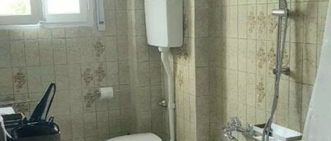 Un baño con bañera, inodoro y ducha.