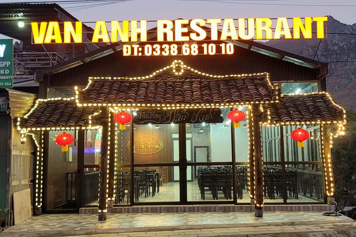 En restaurang som heter Van Anh Restaurant, med en traditionell arkitektonisk stil, kännetecknad av ett tak täckt med tegelpannor och dekorativa ljusslingor.