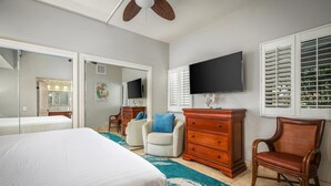 A hotel room with a bed, a dresser, a television, and a chair.