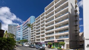 A multi-story parking garage with a modern design, featuring a series of balconies and a clear blue sky in the background. - Regency on Beachwalk City View 1 Bedroom (Honolulu)