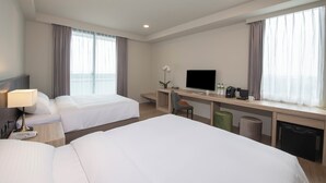 A hotel room with two beds, a desk with a TV, a coffee maker, and a plant. - FLORAMOS HOTEL   (Tianzhong)
