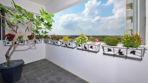 A balcony with potted plants and a view of the city skyline. - FLORAMOS HOTEL   (Tianzhong)