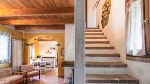 A cozy interior with a wooden ceiling, a staircase with stone steps, and a dining area with a table and chairs. - La casa del Fiume by Interhome (Rialto)