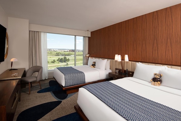 A hotel room with two beds, a desk, a chair, and a large window with a view of the outdoors. - Hotel Polaris (Colorado Springs)