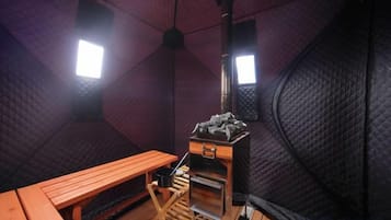 A tent-like room with a wooden bench, a small table, and a stove.